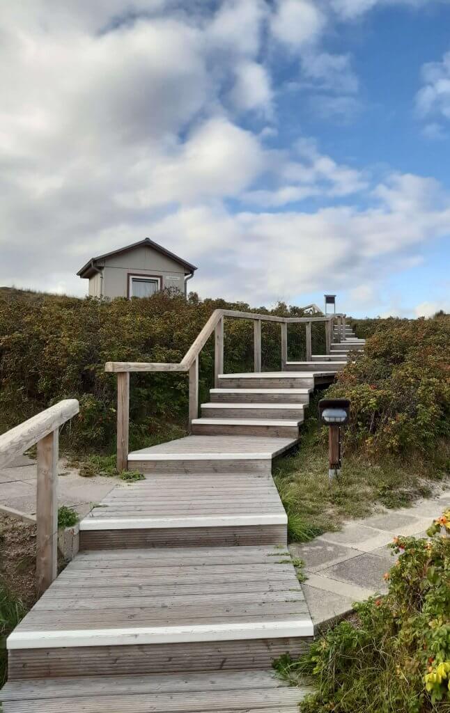 Holztreppe über die Dünen Richtung Himmel. Individueller Weg.